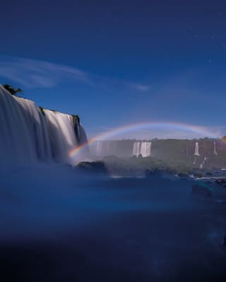 An evening rainbow caused by moonlight in the spray above the cascades of Iguassu Falls