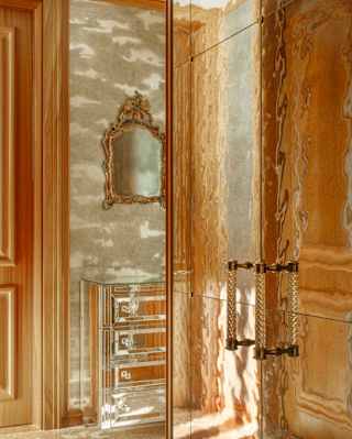 A silver-surfaced dimpled wardrobe reflects a wooden door with a watery rippling effect in a Serenissima Suite detail.