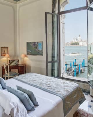 Light and airy hotel suite with open windows and views across the Venetian lagoon