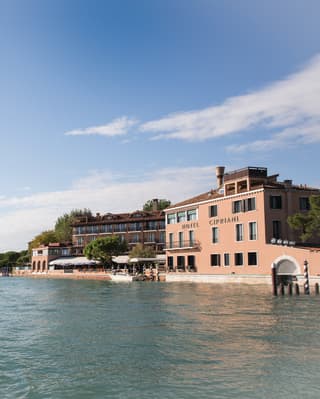 View from across the lagoon of Belmond Hotel Cipriani's coral-coloured exterior