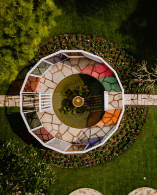 A MITICO installation of a walk-through circle of tinted panels mimics a kaleidoscope in Cipriani's gardens, seen from above.
