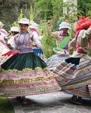 Dancers in traditional Peruvian dress whirling in the gardens of Las Casitas