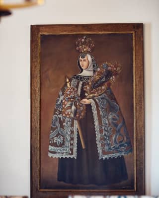 Close-up of a portrait of a regal woman wearing a cloak and floral crown