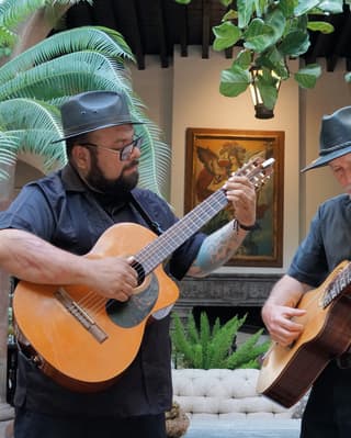 A local acoustic guitar duet entertain diners amid the lush foliage and classic pillars of Restaurant Andanza