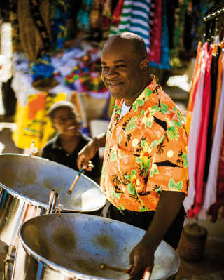 Man in a tropical shirt playing steel drums
