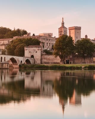 The medieval arches of Pont Saint-Bénézet bathed in a rose light at dusk