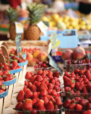 Close-up of punnets of strawberries and fresh peaches on a market stall