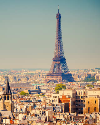 The Eiffel Tower rising above Paris skyline into clear blue skies