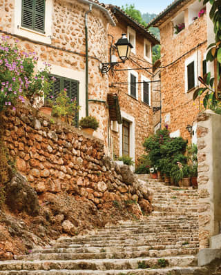 Detail of steps in the village of Fornalutx in Mallorca, climbing steeply through a pretty, narrow lane of stone houses.