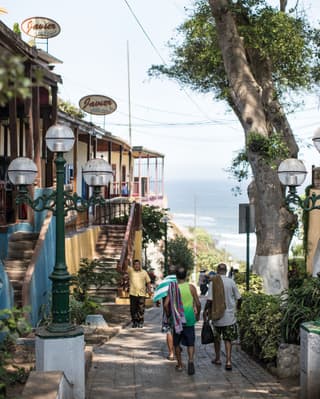 Lima's locals strolling along a shaded boardwalk towards the shore