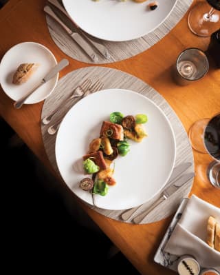 Birds-eye view of pork-belly dish on a white circular plate