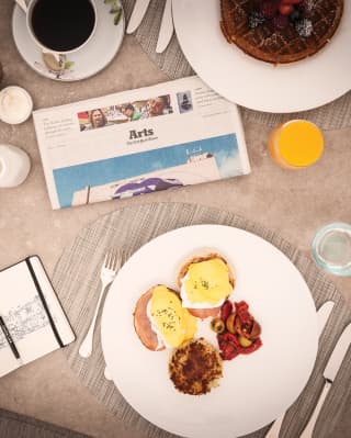 poached eggs breakfast with a folded newspaper nearby