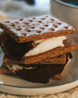 Close-up of a plate of Santa Barbara smores, comprising layers of Grahams Crackers, toasted marshmallow and melted chocolate.
