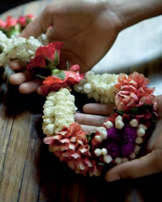 Close-up of two hands holding a sash made of real flowers