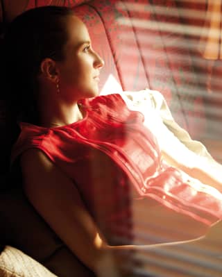 Lady in a red top reclining in a train carriage