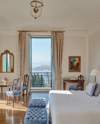 Double-height hotel room with powder blue accents and floor to ceiling windows