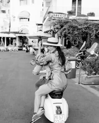 Lady on the back of a vespa in an Italian street