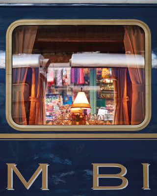 Reflections in a train window with a lamplit carriage inside