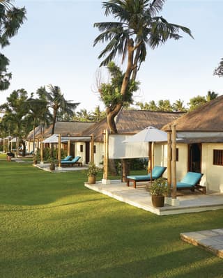 Rows of thatched canary-yellow bungalows among manicured lawns dotted with palms