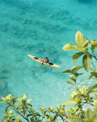 Aerial view of a lone kayaker in crystal clear waters