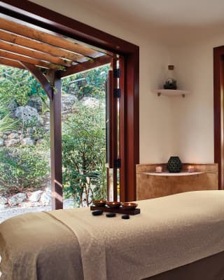 Spa treatment room with two large windows and garden views