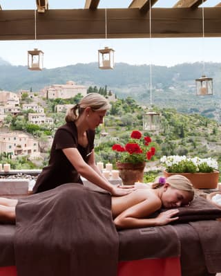 Lady on a massage table receiving a back massage in an outdoor spa gazebo