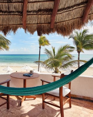 Blue hammock stretched across a terrace, overlooking the Riviera Maya
