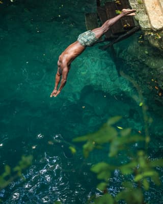 man jumping into a cenote