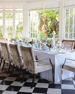 Wedding banquet table in a light-filled conservatory with checkerboard tiles