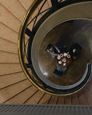 Birds-eye-view of guests having coffee at the bottom of a spiral staircase