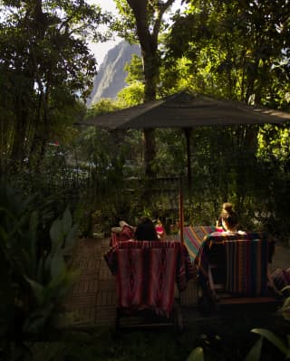 Two guests sat in the gardens facing the Machu Picchu mountains