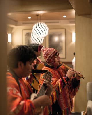 A Peruvian band playing the windpipes and dressed in traditional Peruvian outfits
