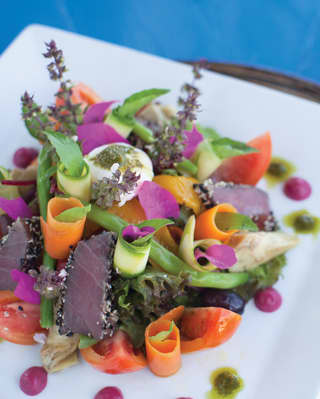 A colourful dish of fresh local ingredients including fish, flowers and vegetables