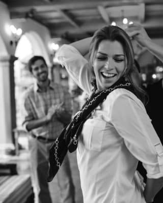 Black and white photo of a lady smiling and dancing