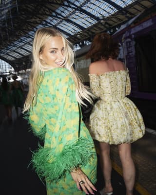 two women in colourful outfits on a train platform