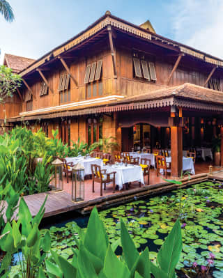 Restaurant terrace overlooking a lily pond beside a timber-framed pagoda