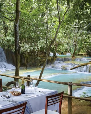 Dining table overlooking the turquoise water of the Kuang Si falls