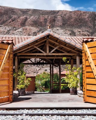 Two barn doors opening to a train platform with a terracotta tiled roof