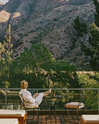 A man relaxing at the Mayu Wilka spa, facing the valley
