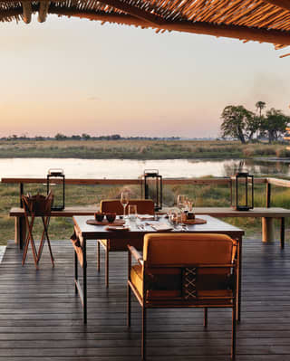 Shaded veranda with an elegant seating area and views across grasslands at sunset