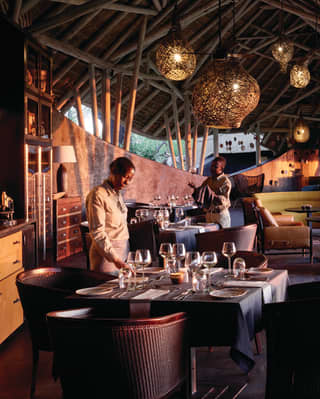 Open-air luxury restaurant hut with chocolate-coloured accents and rattan chandeliers