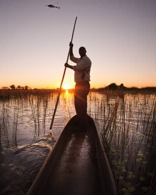 Guests enjoy a sunset canoe expedition in the Botswana wetlands