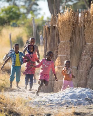 Local delta children playing on sandy tracks through their village