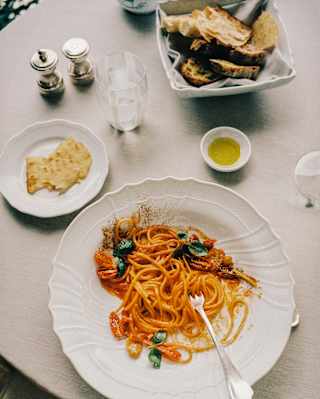 Spaghetti in sauce with fresh cherry tomatoes is served with bread and oil in a detail from a private dinner at La Terrazza.