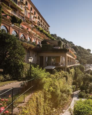 Villa italiana in stile classico sulla collina circondata da verdeggianti giardini mediterraneai