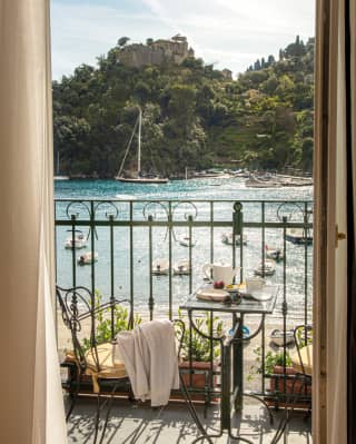 Hotel suite terrace with breakfast table, overlooking Portofino Bay