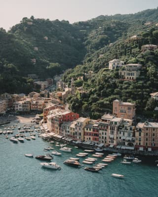 An aerial view of Portofino shows the elegance of the pastel buildings that cluster at the waters edge and dot the verdant hills