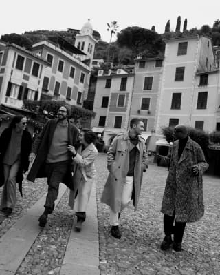 Image en noir et blanc de cinq personnes marchant le long du port de Portofino