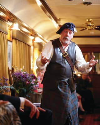 Storyteller in traditional highland dress performing a Scottish folk tale