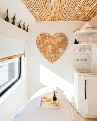 Heart-shaped wall art hanging in a white wood-panelled spa treatment cabin